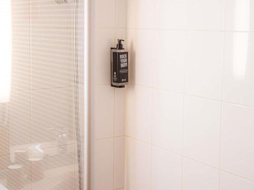 a soap dispenser on the wall of a bathroom at ibis Paris Porte D'Orleans in Montrouge
