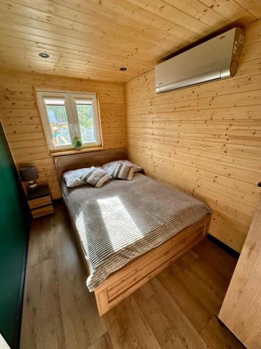a bedroom with a bed in a wooden room at Chatka u Mańka in Świeradów-Zdrój