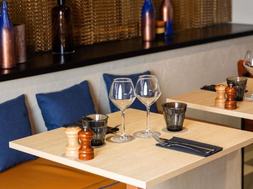 a wooden table with two wine glasses on it at ibis Paris Porte D'Orleans in Montrouge