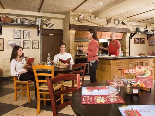 a group of people sitting at a table in a kitchen at ibis Paris Porte D'Orleans in Montrouge