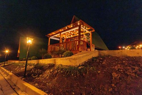 a wooden house at night with a street light at Chácara Cabanas e Eventos Peniel in Campina Grande do Sul
