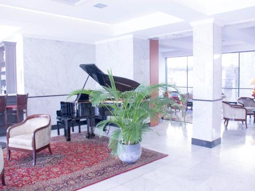 a lobby with a piano and a potted plant at ibis Périgueux Centre in Périgueux