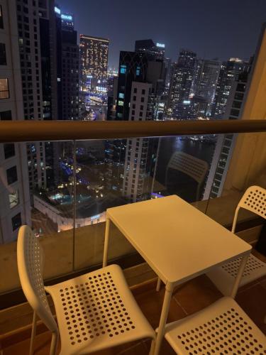 einen Tisch und Stühle auf dem Balkon mit Blick auf die Skyline der Stadt in der Unterkunft Shams Wa Bahar Vacation Homes Rental in Dubai
