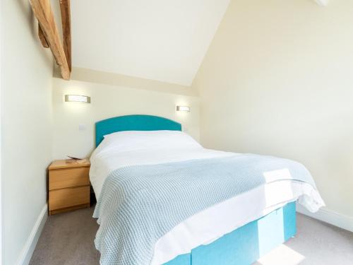 a bedroom with a blue bed and a wooden dresser at 2 Bed in Chulmleigh 72791 in Coldridge
