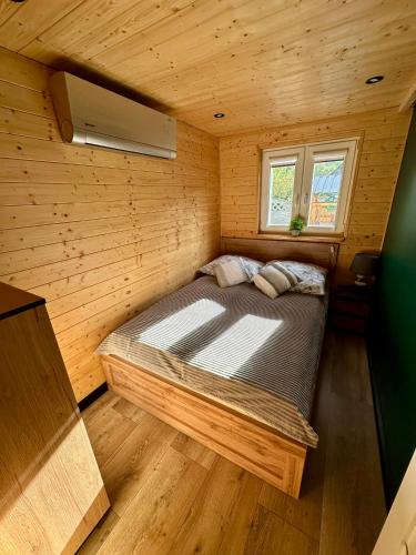 a bedroom with a bed in a wooden room at Chatka u Mańka in Świeradów-Zdrój
