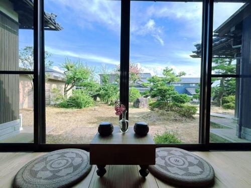 a table with vases on it in front of a window at Hot Spring Guest House Mikunien - Vacation STAY 18669v in Sakai