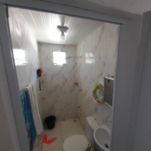 a white bathroom with a toilet and a sink at Casa cop30 in Belém