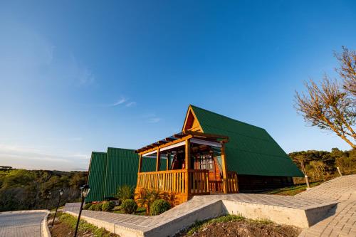 a house with a green roof and stairs at Chácara Cabanas e Eventos Peniel in Campina Grande do Sul