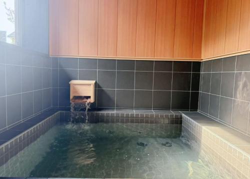 a bathroom with a tub with water in it at Hot Spring Guest House Mikunien - Vacation STAY 18629v in Sakai