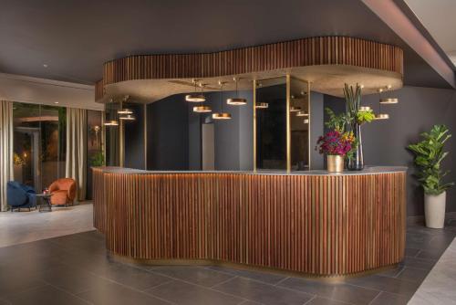 a lobby with a wooden counter with flowers on it at NH Collection Roma Centro in Rome