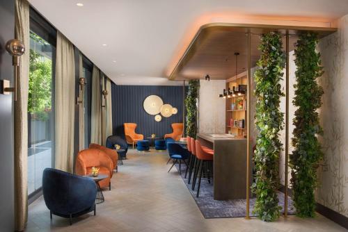 a lobby with a bar with plants on the walls at NH Collection Roma Centro in Rome