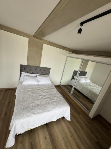 sypialnia z dużym łóżkiem i lustrem w obiekcie Mutuo 109 w mieście Tijuana