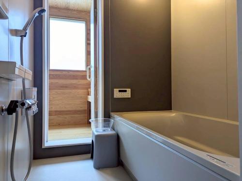 a bathroom with a large tub and a shower at Minamiaso Sauna 5GAKU - Vacation STAY 24183v in Minami Aso