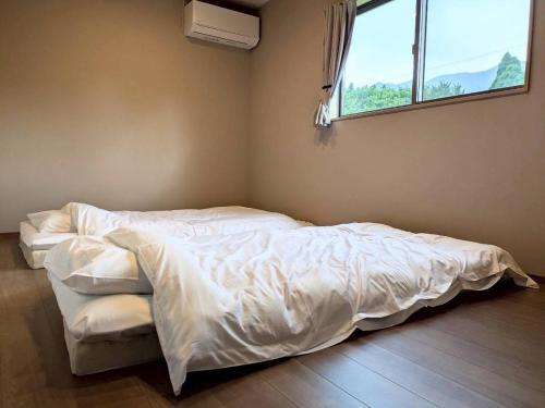 an unmade bed in a room with a window at Minamiaso Sauna 5GAKU - Vacation STAY 23343v in Minami Aso