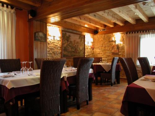 uma sala de jantar com mesas e cadeiras num restaurante em C.T.R. Camino de la Fuentona em Cabrejas del Pinar