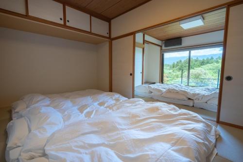 a large white bed in a room with a window at Fujinomiya - House - Vacation STAY 20037 in Fujinomiya