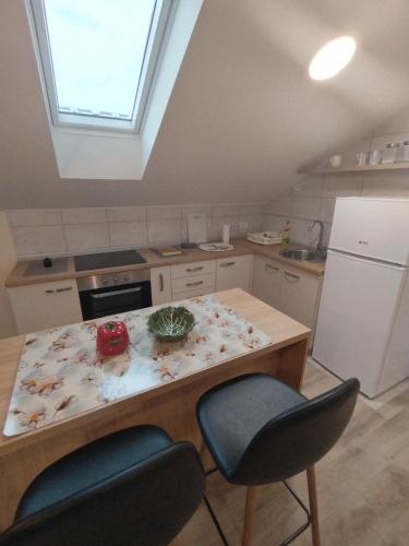 a kitchen with a counter with two chairs and a table at Belgrade City Home Beograd in Belgrade