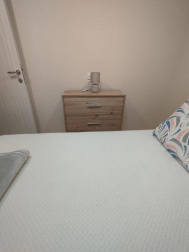 a bedroom with a bed and a dresser with a pillow at Belgrade City Home Beograd in Belgrade