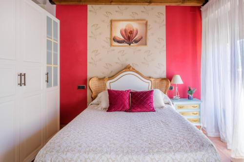 a bedroom with red walls and a bed with pink pillows at Casa Maza Apartamentos in Biescas