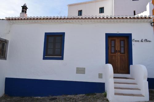 a white and blue building with a door and stairs at Casa do Chico in Mértola