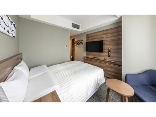 a bedroom with a white bed and a blue chair at Far East Village Hotel Tokyo Ariake - Vacation STAY 26441v in Tokyo