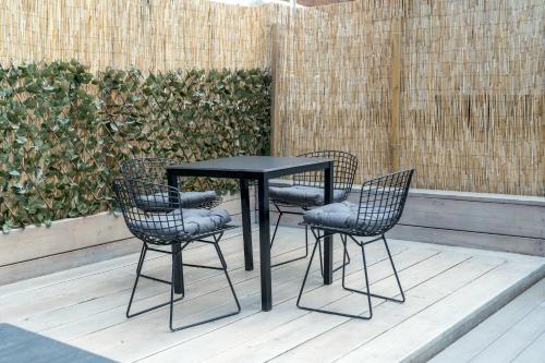 a black table and four chairs on a patio at Stylish apartment in the heart of Kingston Town Centre in Kingston upon Thames