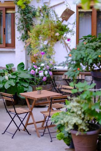 a wooden table and chairs with flowers and plants at Casa Maza Apartamentos in Biescas