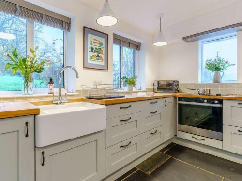 a kitchen with white cabinets and a sink at 4 Bed in Monmouth 42868 in Cwmcarvan