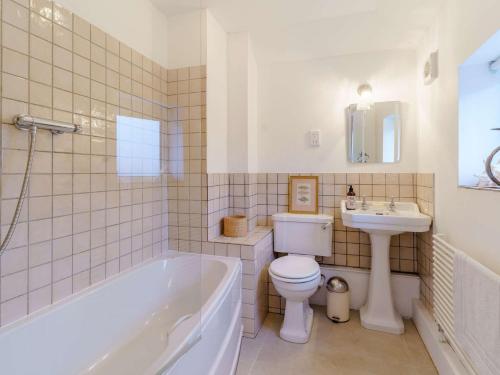 a bathroom with a tub and a toilet and a sink at 4 Bed in Monmouth 42868 in Cwmcarvan