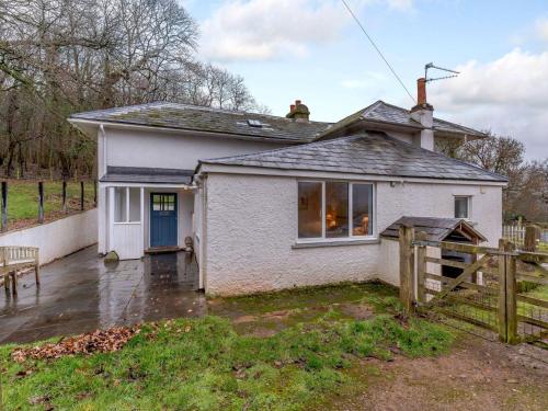 a small white house with a wooden fence at 4 Bed in Monmouth 42868 in Cwmcarvan