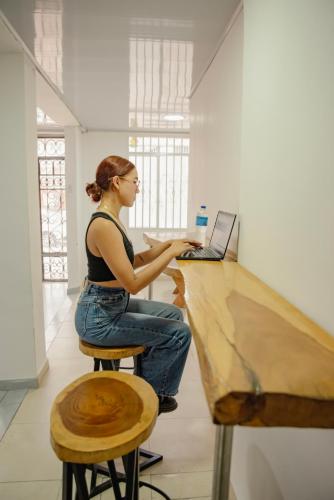 a woman sitting at a desk with a laptop computer at Casa Cándido in Neiva