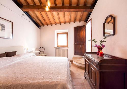 een slaapkamer met een groot bed en een houten plafond bij Casa Burelli in Montalcino