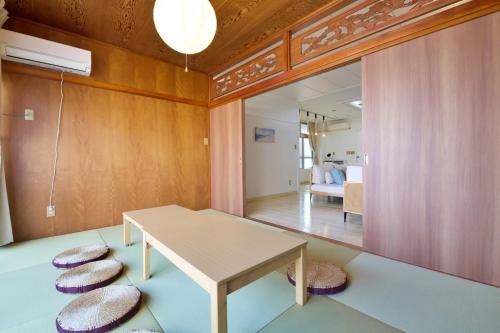 糸満市にあるZA155 Itoman Inn 2nd and 3rd floors - Vacation STAY 27211vのテーブルとクッションチェア2脚が備わる客室です。