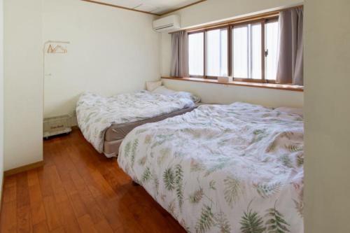 deux lits dans une petite pièce avec une fenêtre dans l'établissement Ishigaki - House - Vacation STAY 30825v, à Ishigaki