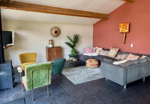 a living room with a couch and chairs at Groepsverblijf Het Bonte Paard in Dwingeloo