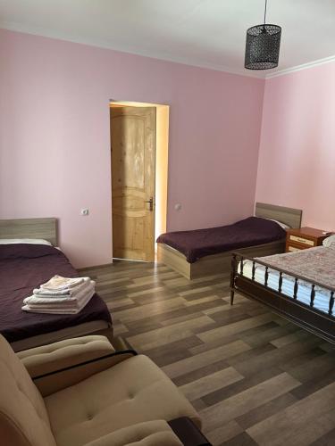 a room with two beds and a couch in it at DreamLand Lagodekhi & Wine Cellar in Lagodekhi