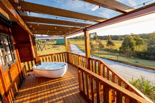 a bath tub sitting on the deck of a house at Chácara Cabanas e Eventos Peniel in Campina Grande do Sul
