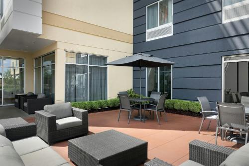 a patio with a table and chairs and an umbrella at Fairfield Inn & Suites by Marriott Fayetteville North in Fayetteville