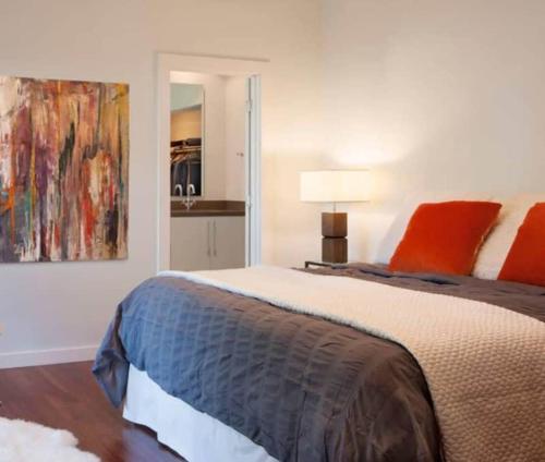 a bedroom with a bed and a painting on the wall at Downtown Nola 2bd 2bth Condo in New Orleans