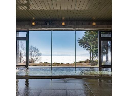 an open glass door with a view of a body of water at Takamine Kogen Hotel - Vacation STAY 36239v in Shin-kazawa