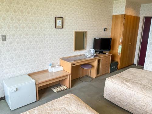 a hotel room with a desk and a television at Takamine Kogen Hotel - Vacation STAY 36239v in Shin-kazawa