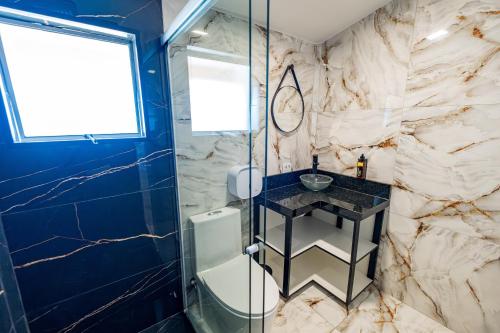 a bathroom with a glass shower and a sink at Chácara Cabanas e Eventos Peniel in Campina Grande do Sul