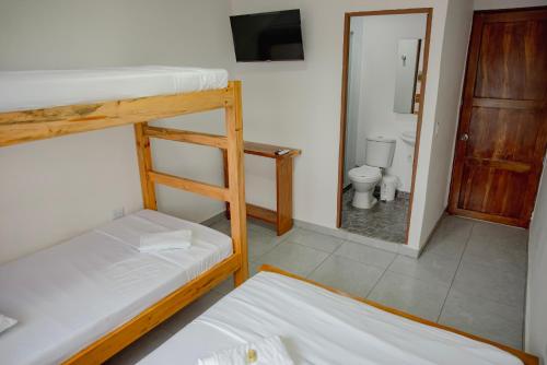 a room with two bunk beds and a bathroom with a toilet at Casa Cándido in Neiva