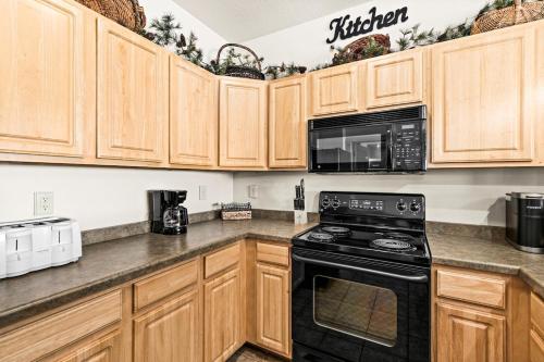 a kitchen with wooden cabinets and a black stove top oven at Majestic Lake Views 1BR King Suite and Heated Pools in Two Harbors