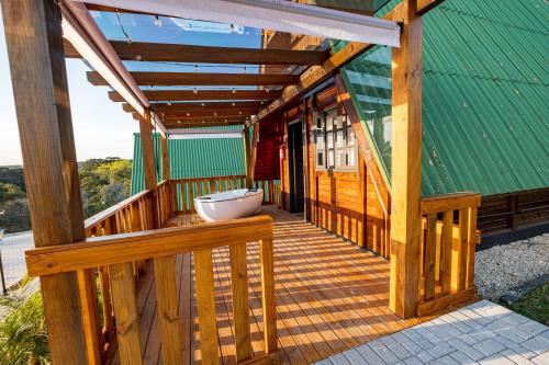 a wooden porch of a house with a green roof at Chácara Cabanas e Eventos Peniel in Campina Grande do Sul