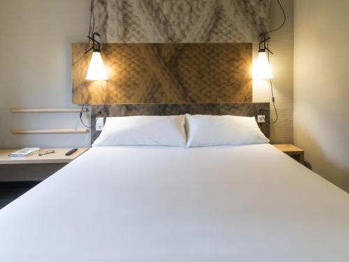 a bedroom with a large bed with two white pillows at ibis Tilburg in Tilburg