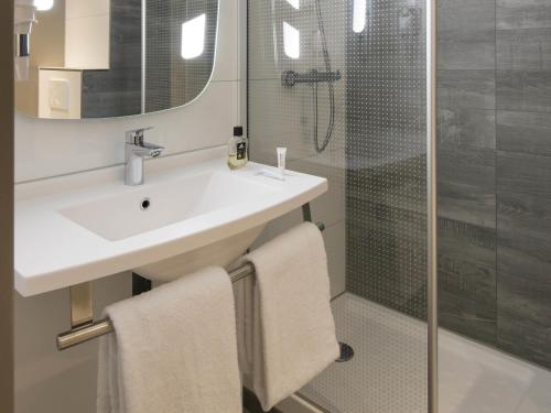 a bathroom with a sink and a shower at ibis Tilburg in Tilburg