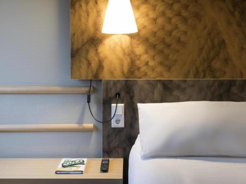 a bedroom with a bed and a lamp next to a table at ibis Tilburg in Tilburg