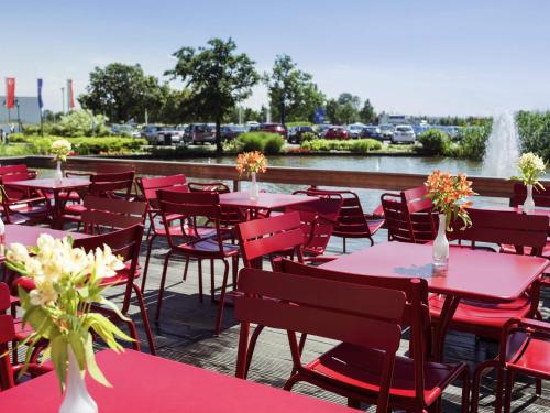 a deck with tables and chairs and a fountain at Ibis Schiphol Amsterdam Airport in Badhoevedorp