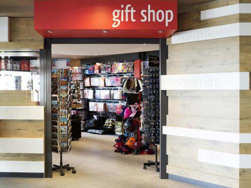 a gift shop with a red sign in a store at Ibis Schiphol Amsterdam Airport in Badhoevedorp